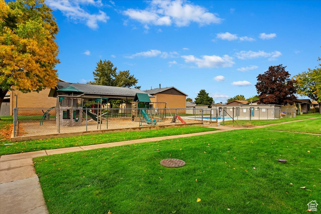 View of play area featuring a swimming pool and a lawn