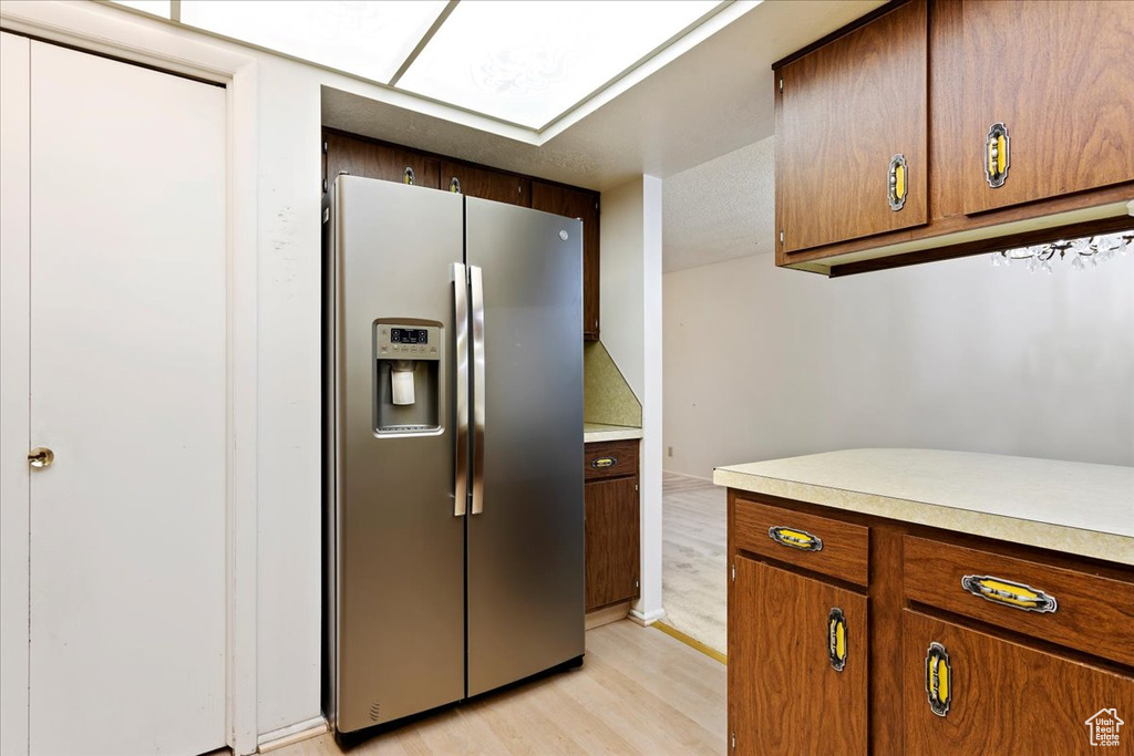 Kitchen featuring light hardwood / wood-style floors and stainless steel fridge