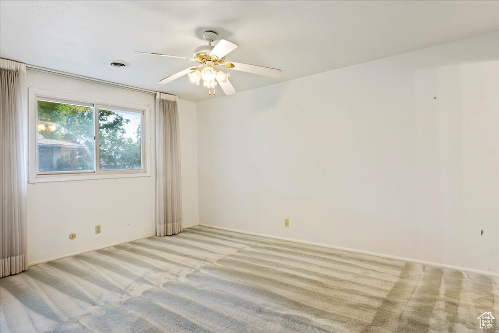 Carpeted empty room with ceiling fan