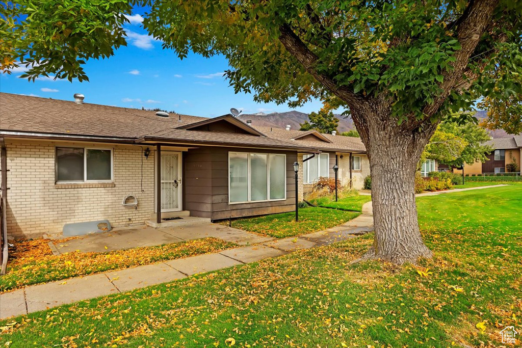 Ranch-style home with a front lawn and a patio