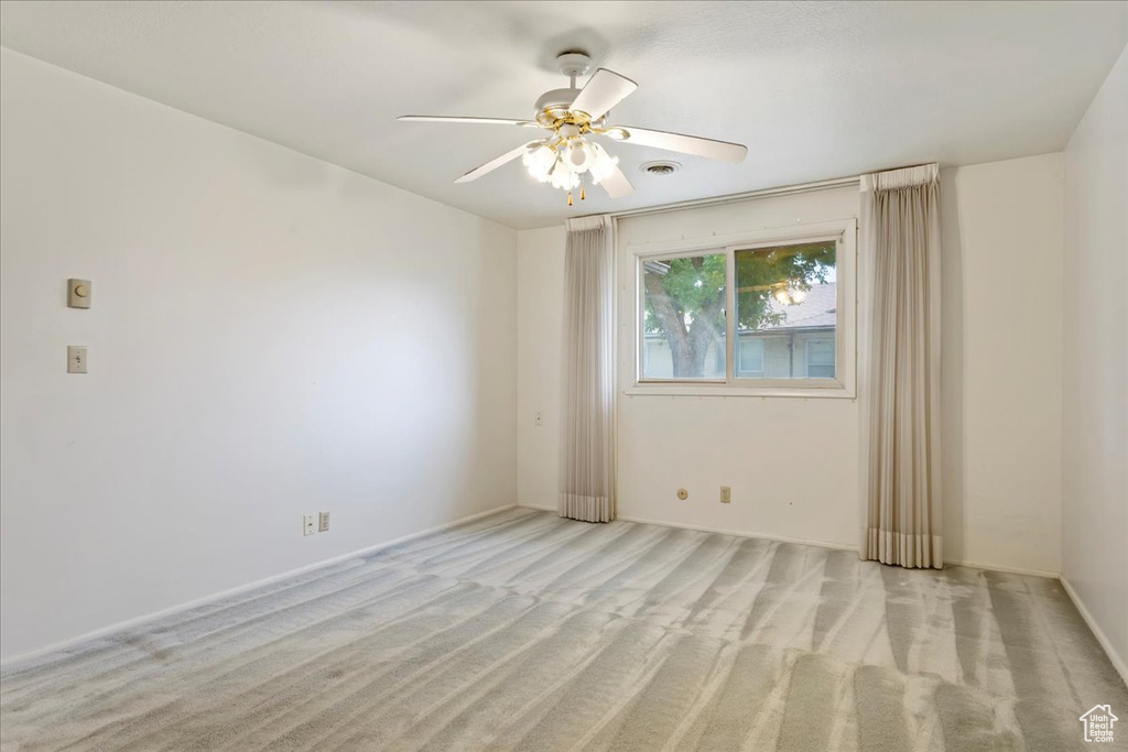 Spare room featuring light carpet and ceiling fan