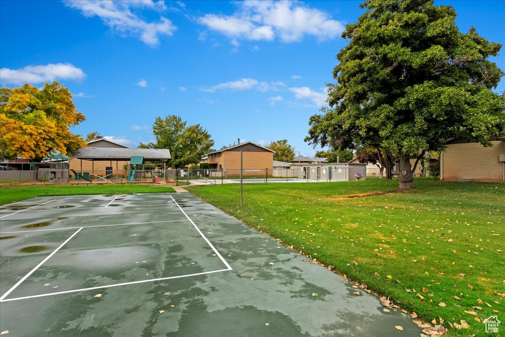 View of sport court with a yard and a playground