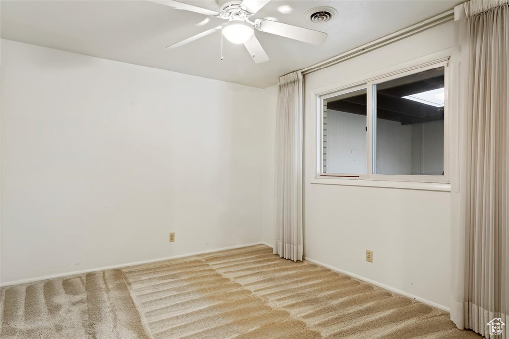 Carpeted empty room with ceiling fan