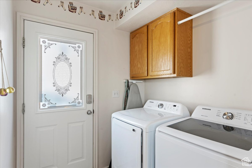 Washroom with cabinets and washing machine and clothes dryer