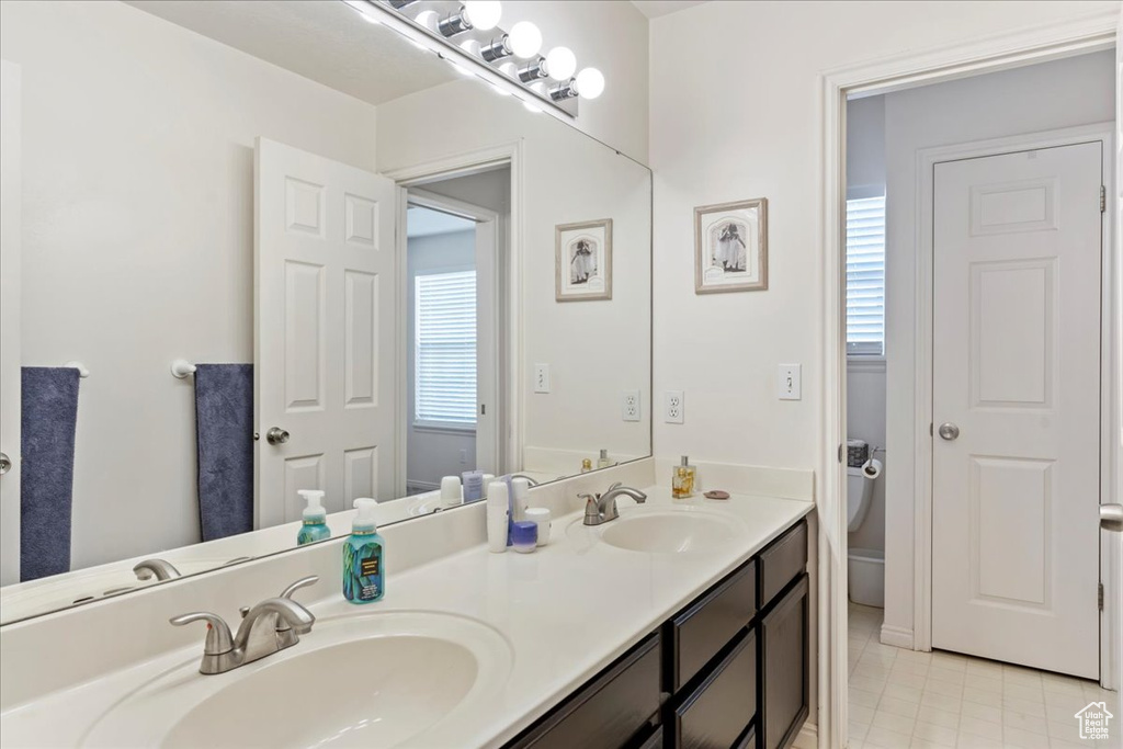 Bathroom featuring vanity, toilet, and tile patterned floors