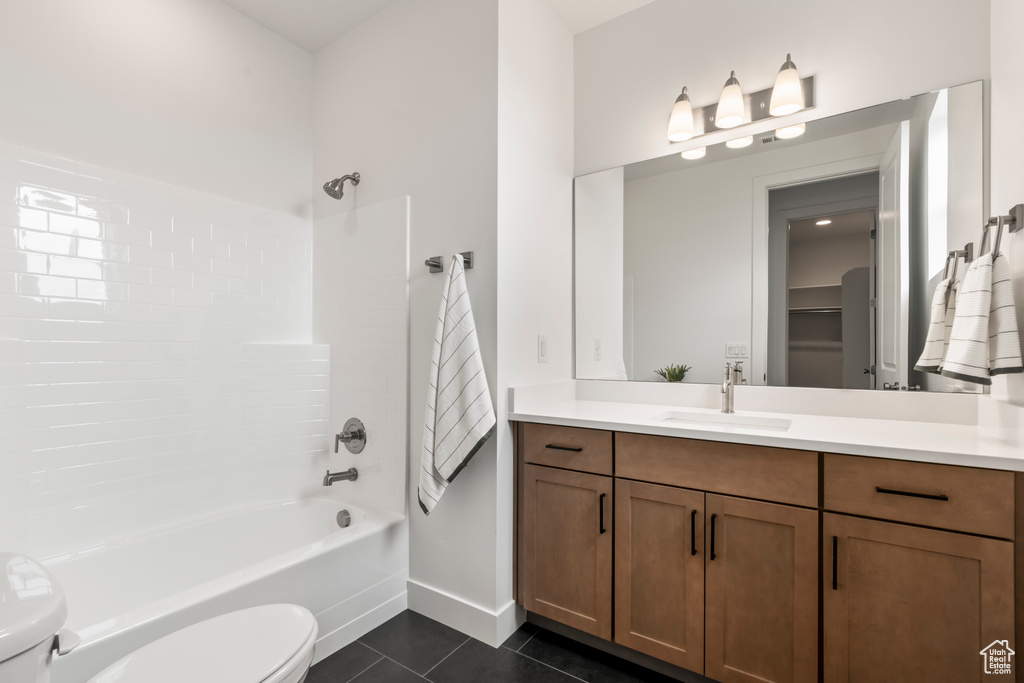 Full bathroom featuring  shower combination, vanity, toilet, and tile patterned floors