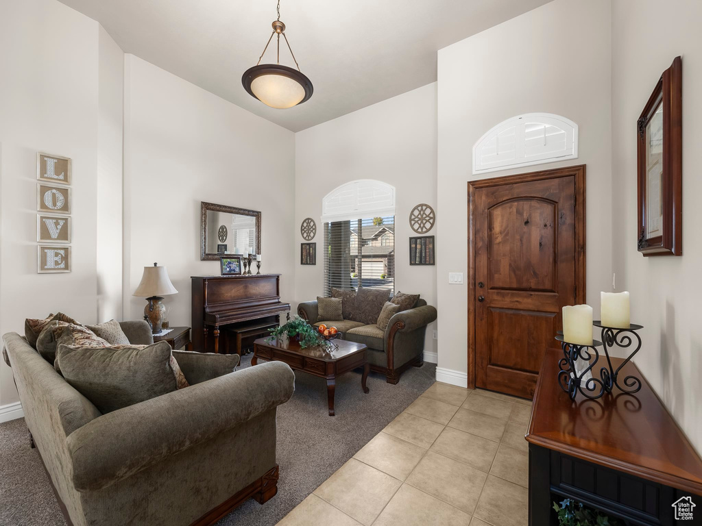 Living room featuring light tile patterned floors and a high ceiling