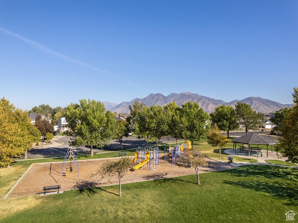 View of home\'s community featuring a playground, a mountain view, and a yard