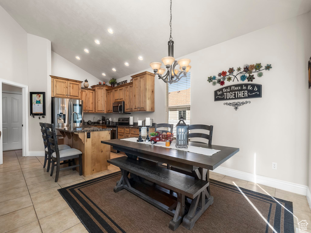 Tiled dining room featuring a notable chandelier, high vaulted ceiling, and sink