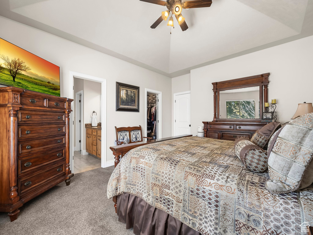 Bedroom with ceiling fan, light colored carpet, a spacious closet, a closet, and ensuite bath