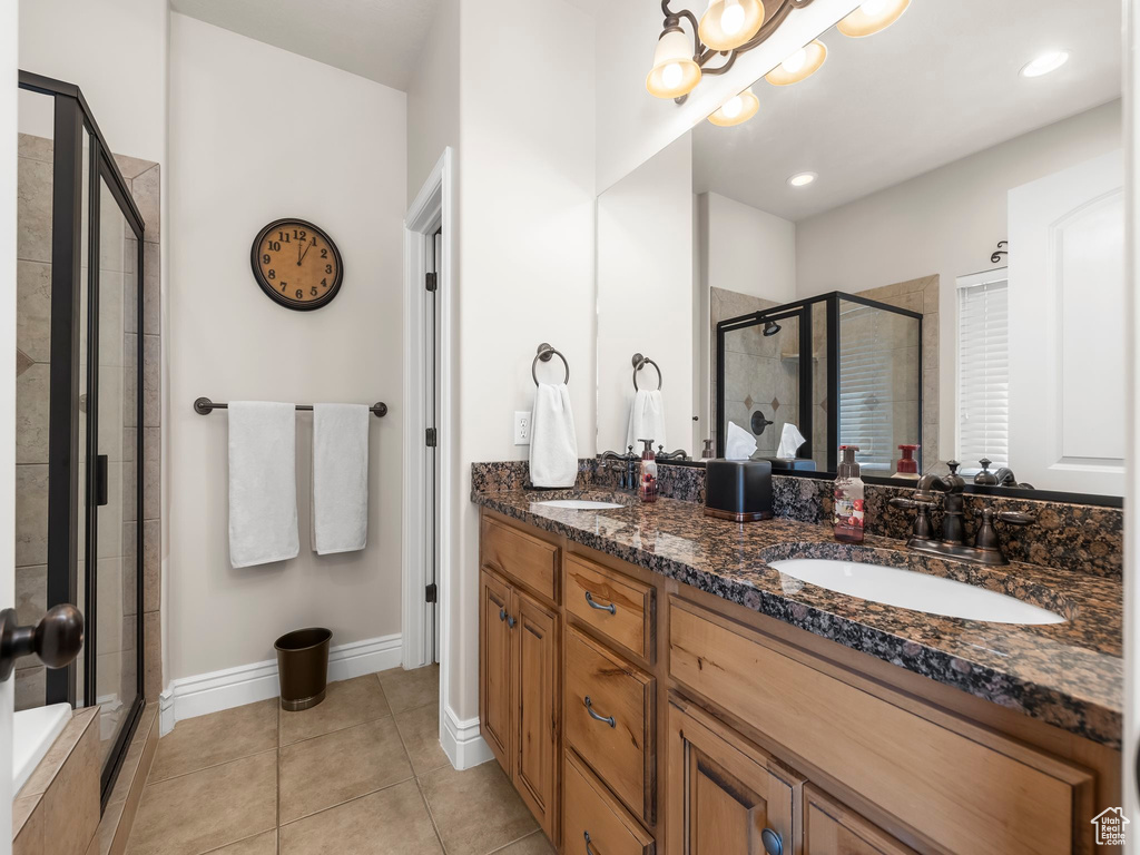 Bathroom featuring tile patterned flooring, an enclosed shower, and vanity