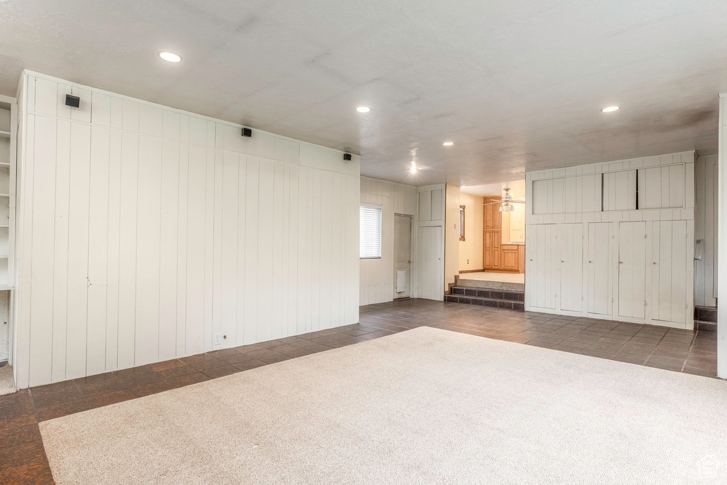 Carpeted empty room with wood walls