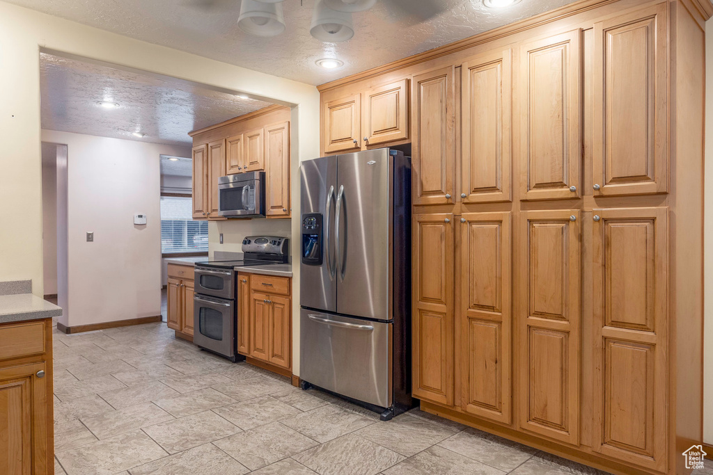 Kitchen featuring a textured ceiling and stainless steel appliances