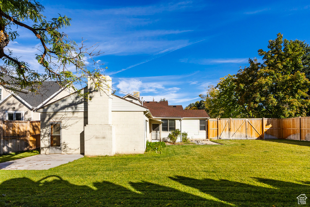 Rear view of house with a yard and a patio