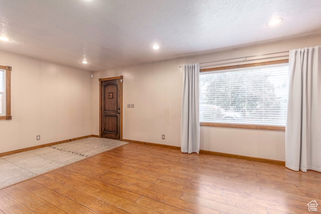 Unfurnished room featuring light hardwood / wood-style flooring and a textured ceiling