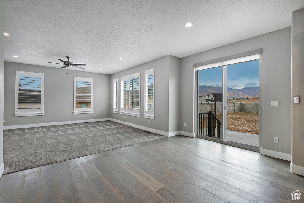 Spare room with ceiling fan, a textured ceiling, and hardwood / wood-style floors