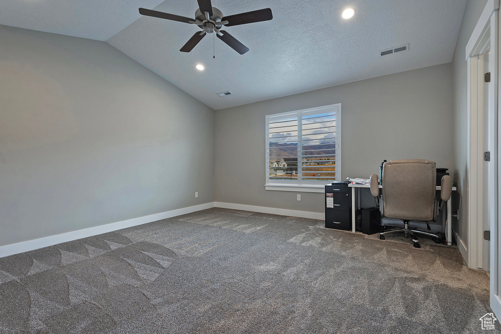 Office featuring ceiling fan, a textured ceiling, lofted ceiling, and dark colored carpet