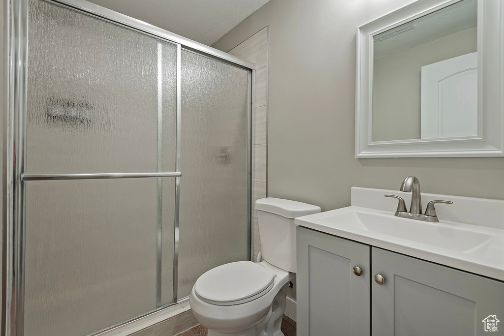 Bathroom featuring vanity, hardwood / wood-style floors, toilet, and walk in shower