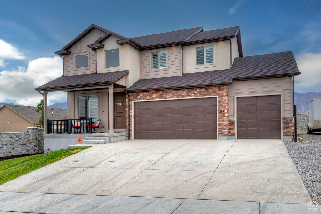 View of front of home with covered porch and a garage