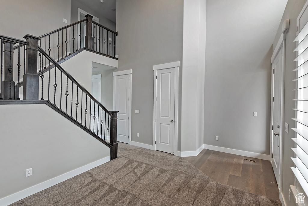 Foyer featuring a towering ceiling and wood-type flooring