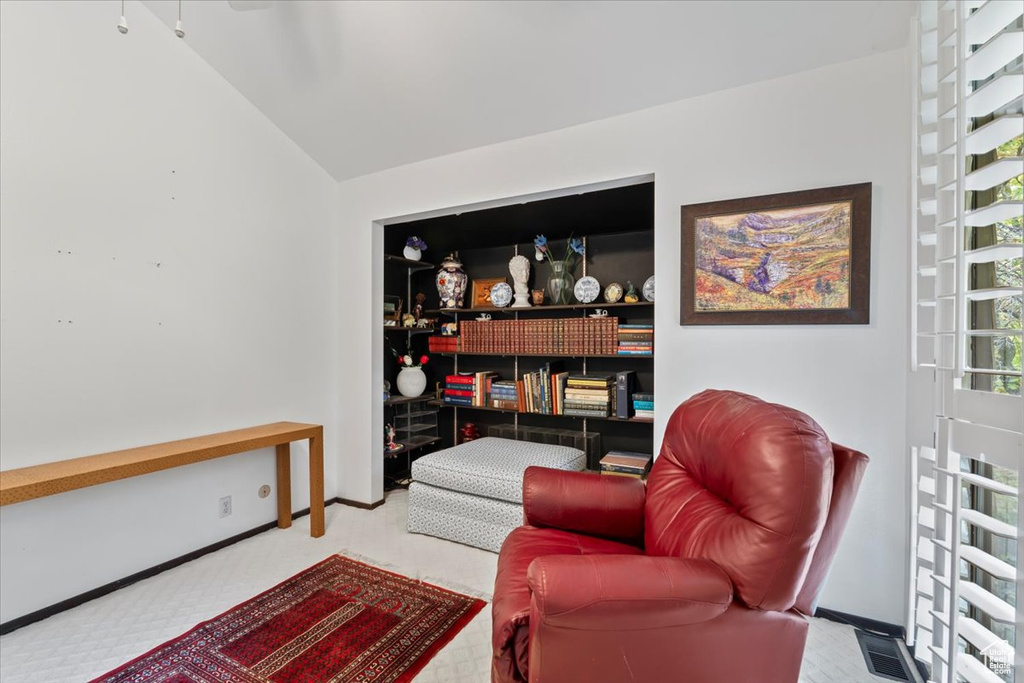 Living area featuring light carpet and lofted ceiling