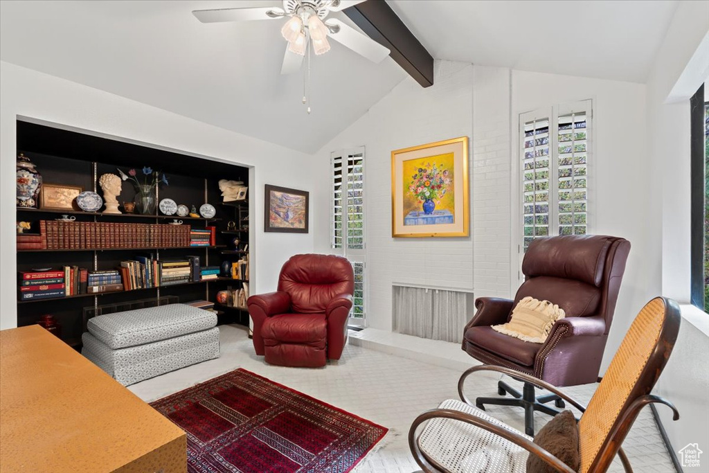 Living area featuring lofted ceiling with beams, wood-type flooring, and ceiling fan