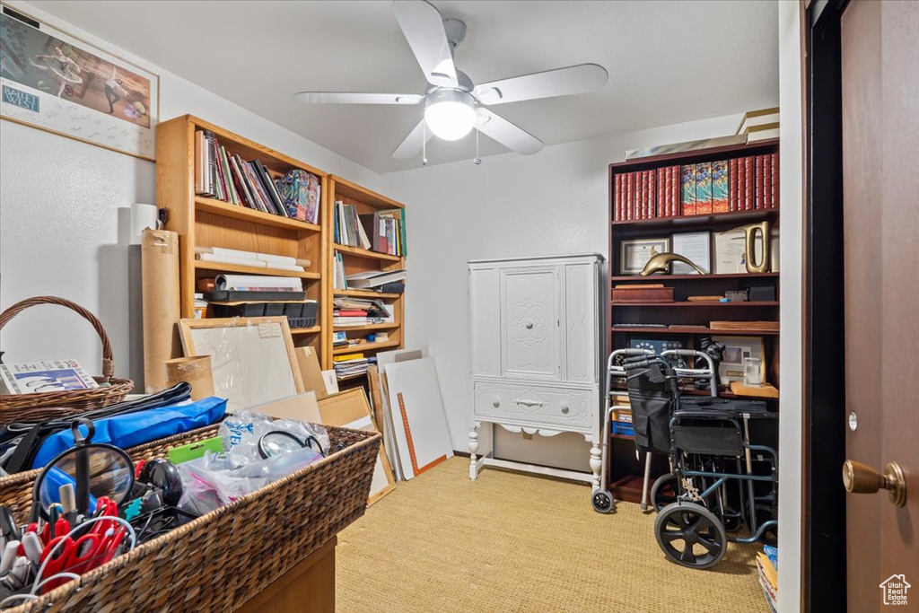 Carpeted home office featuring ceiling fan