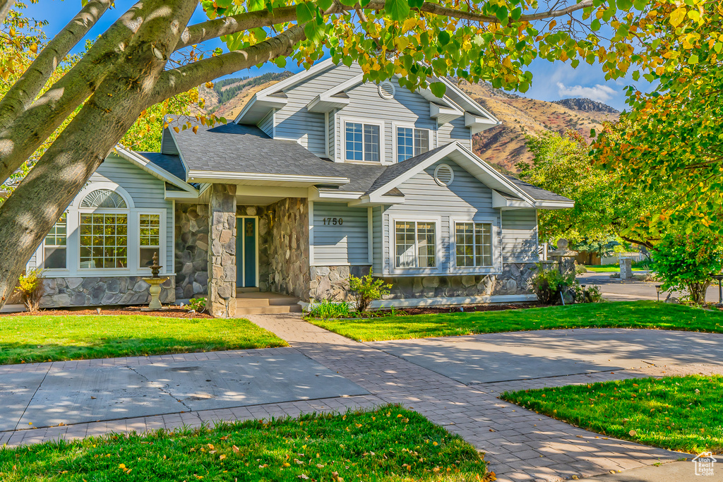 View of front facade featuring a mountain view and a front yard