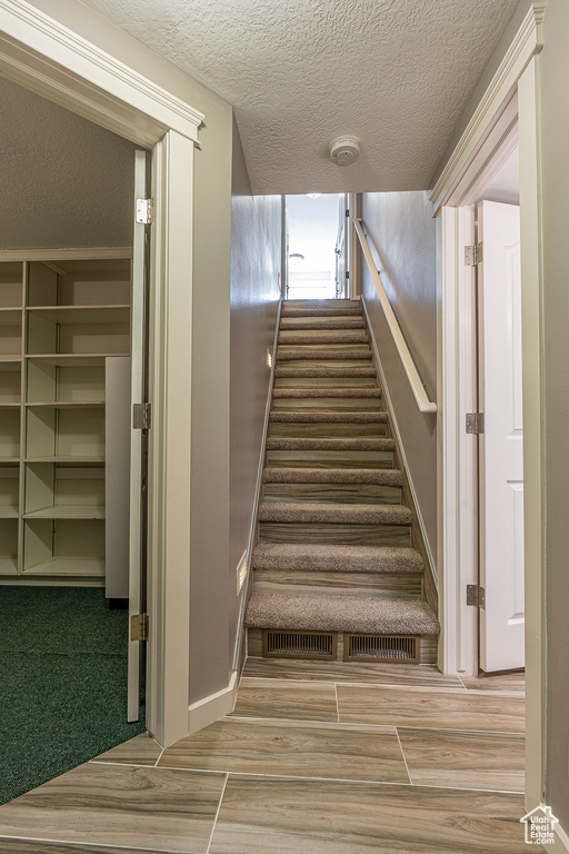 Staircase with a textured ceiling