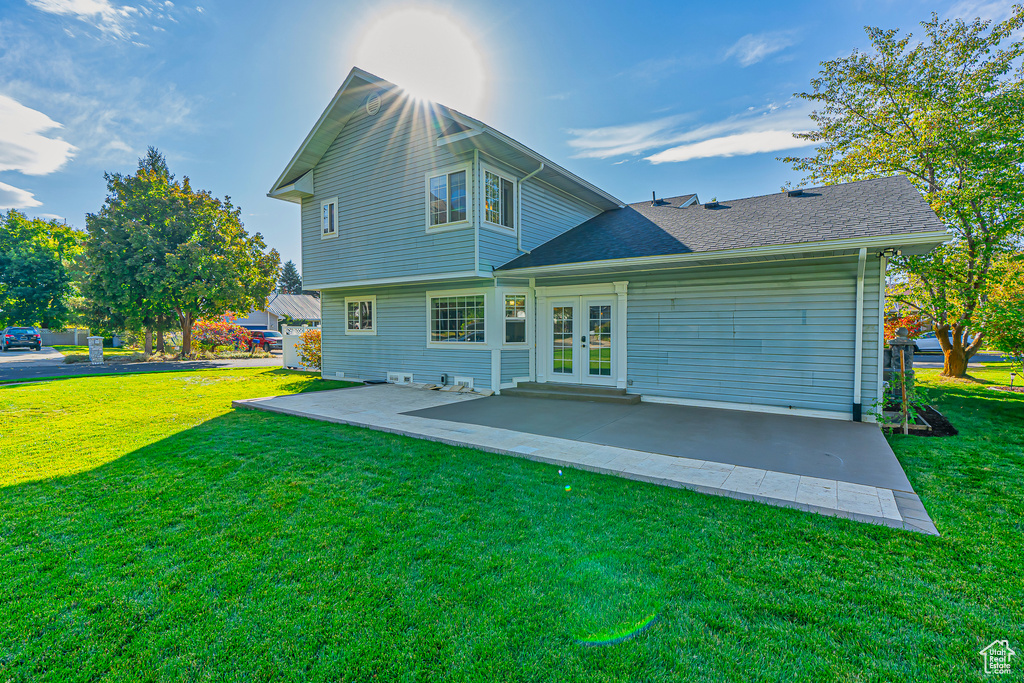 Rear view of property with a patio, french doors, and a lawn