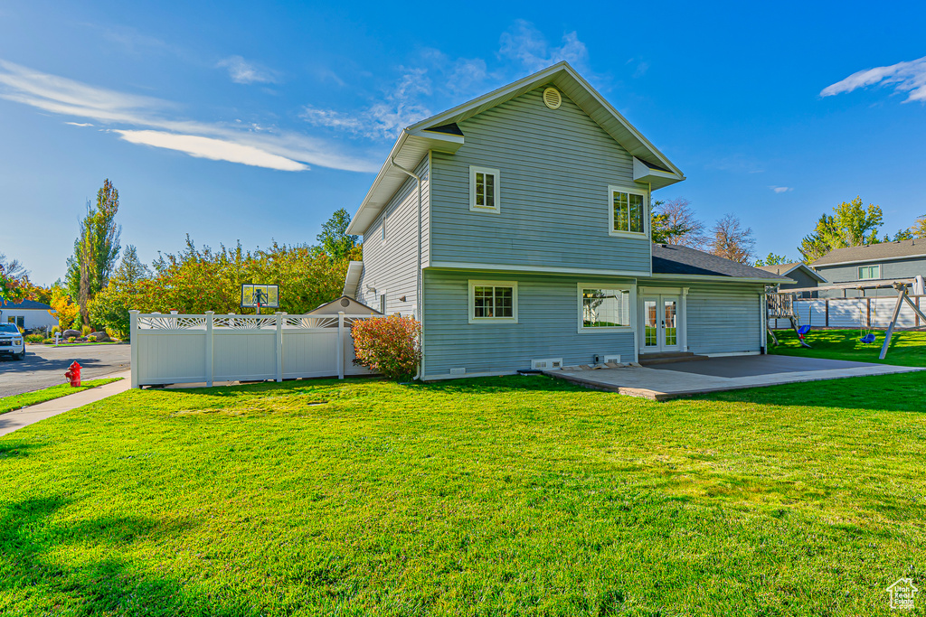 Back of house with a yard and french doors