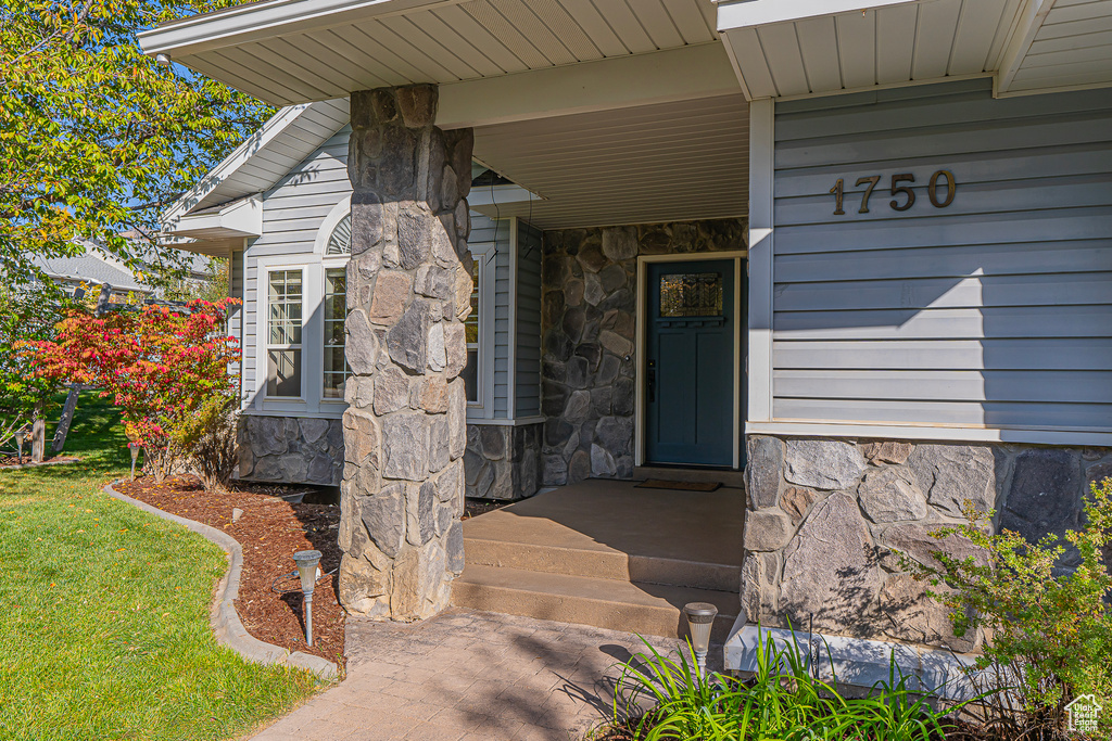 View of exterior entry with a lawn