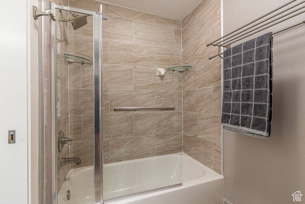 Bathroom featuring bath / shower combo with glass door