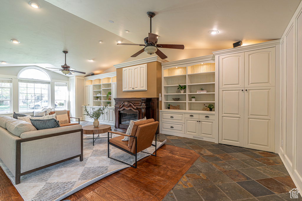 Living room featuring ceiling fan and vaulted ceiling