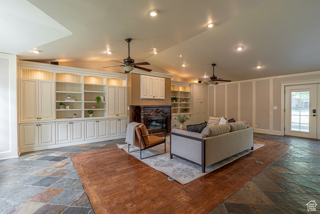 Living room with french doors, vaulted ceiling, built in shelves, and ceiling fan