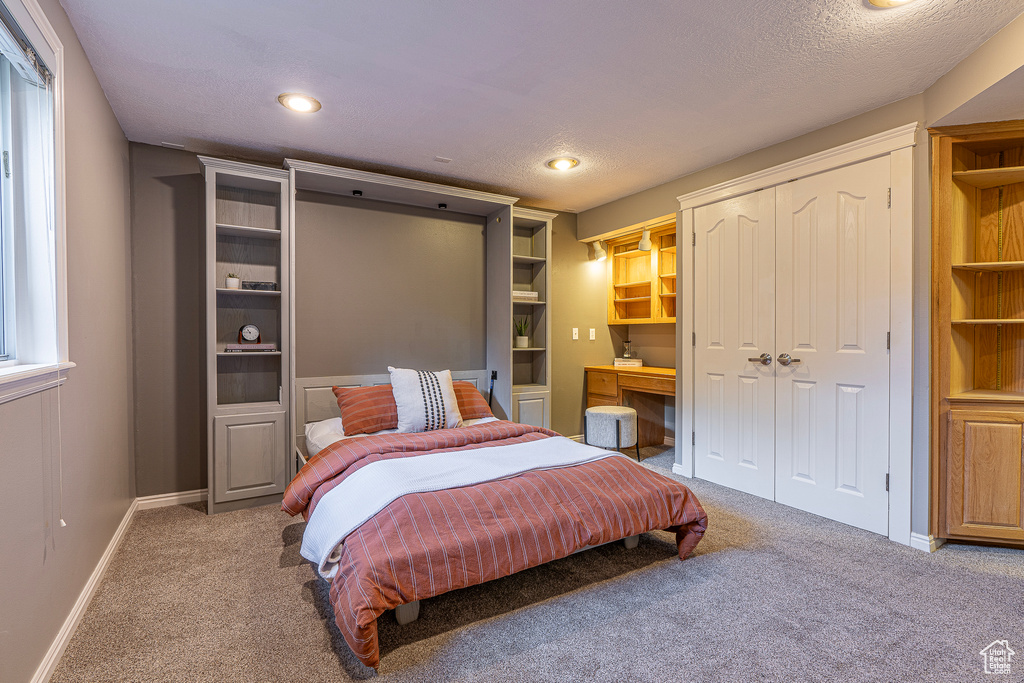 Bedroom with a textured ceiling and carpet flooring