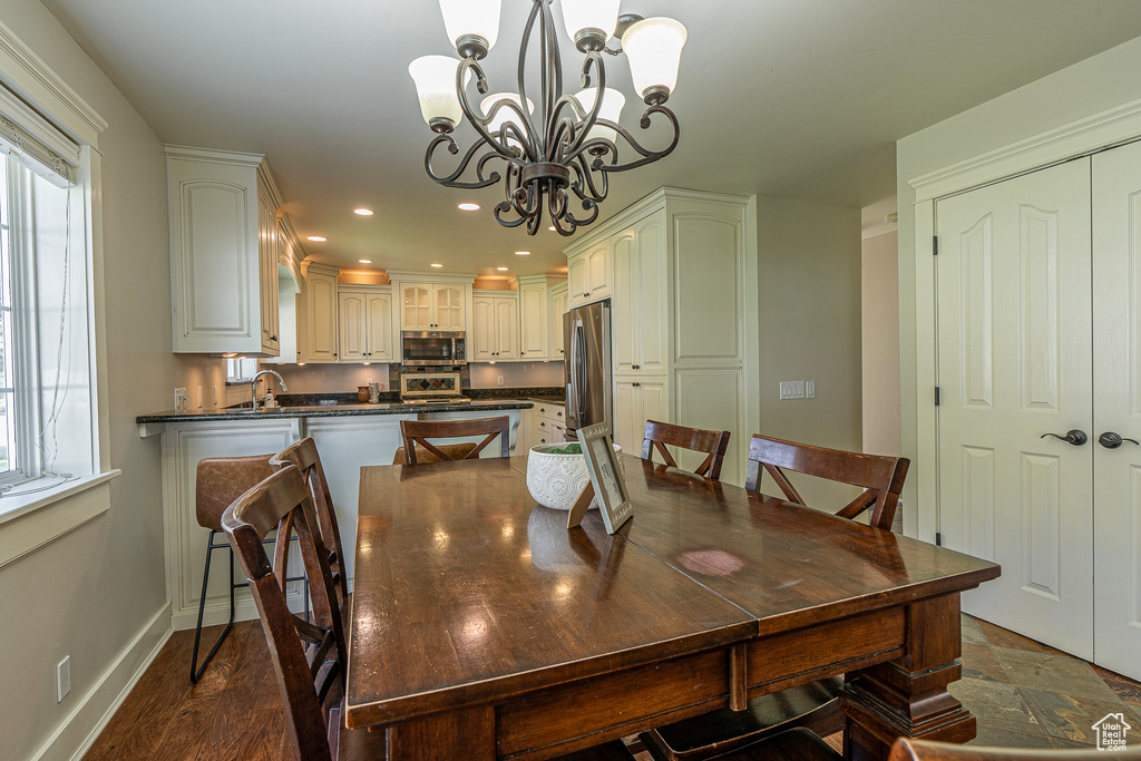 Dining room with an inviting chandelier, dark hardwood / wood-style floors, and sink