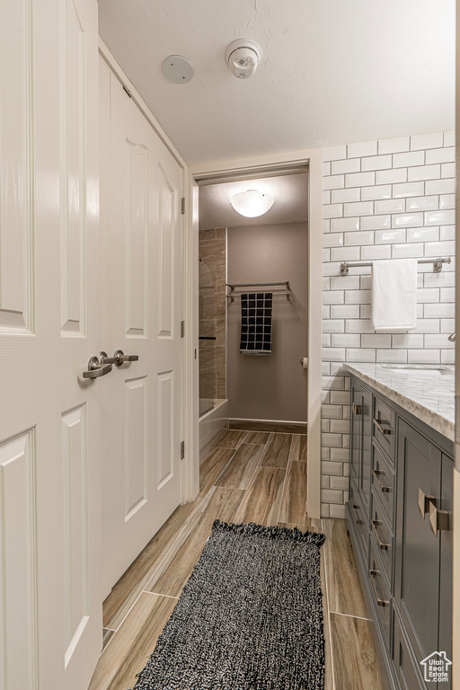 Bathroom featuring vanity, a textured ceiling, hardwood / wood-style flooring, and a shower