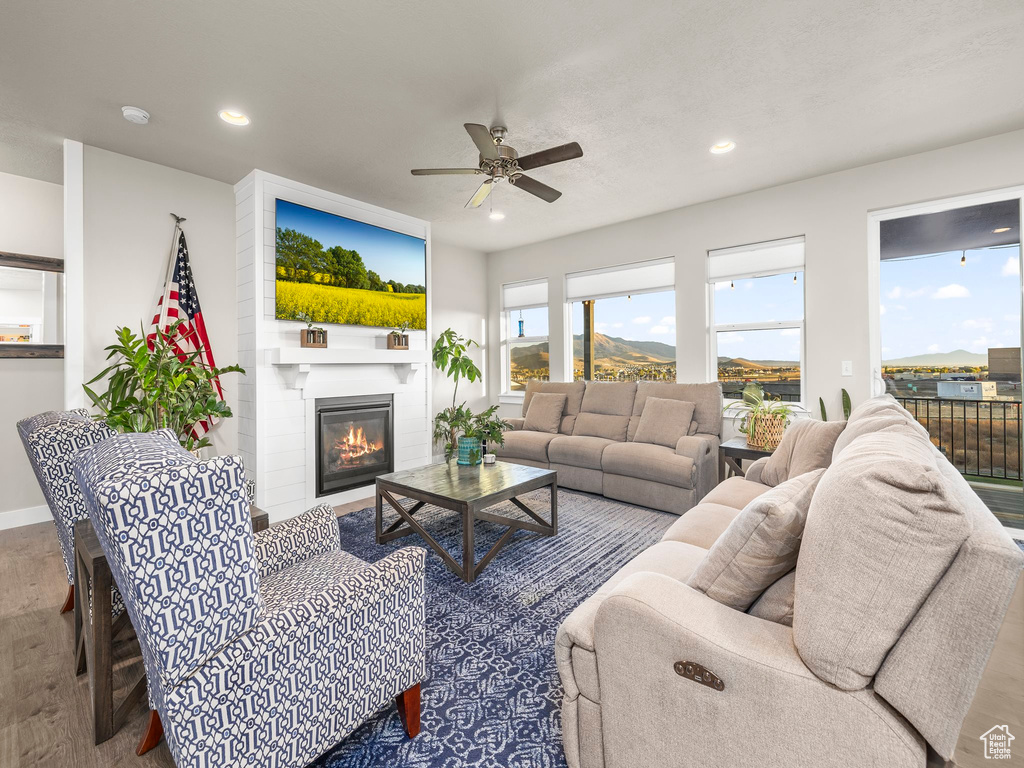 Living room with ceiling fan and hardwood / wood-style flooring