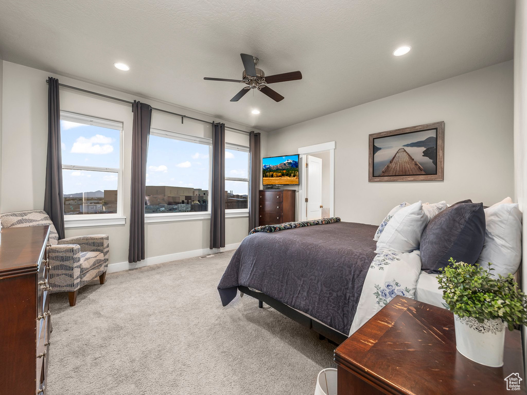 Carpeted bedroom featuring ceiling fan