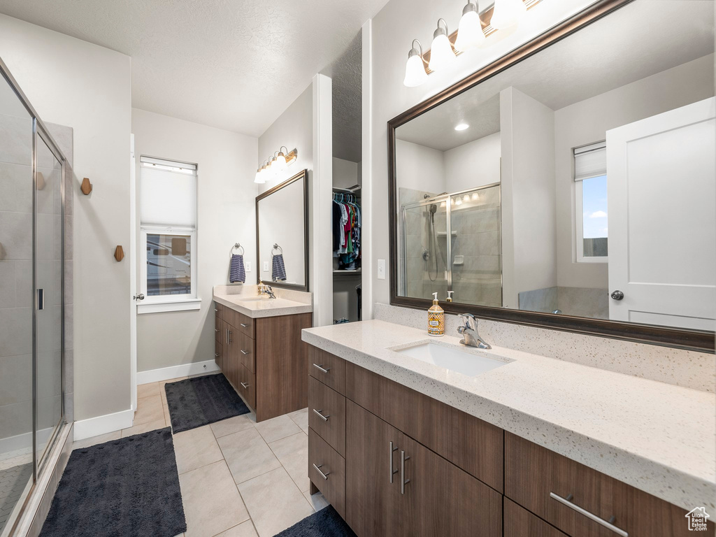 Bathroom featuring vanity, tile patterned floors, a textured ceiling, and walk in shower