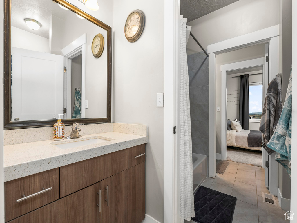 Bathroom with vanity, shower / tub combo, a textured ceiling, and tile patterned floors