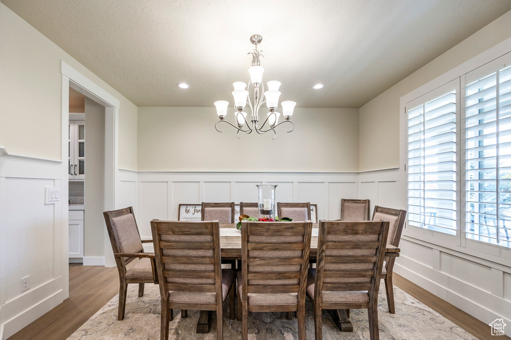 Dining room featuring a notable chandelier, wood-type flooring, and plenty of natural light