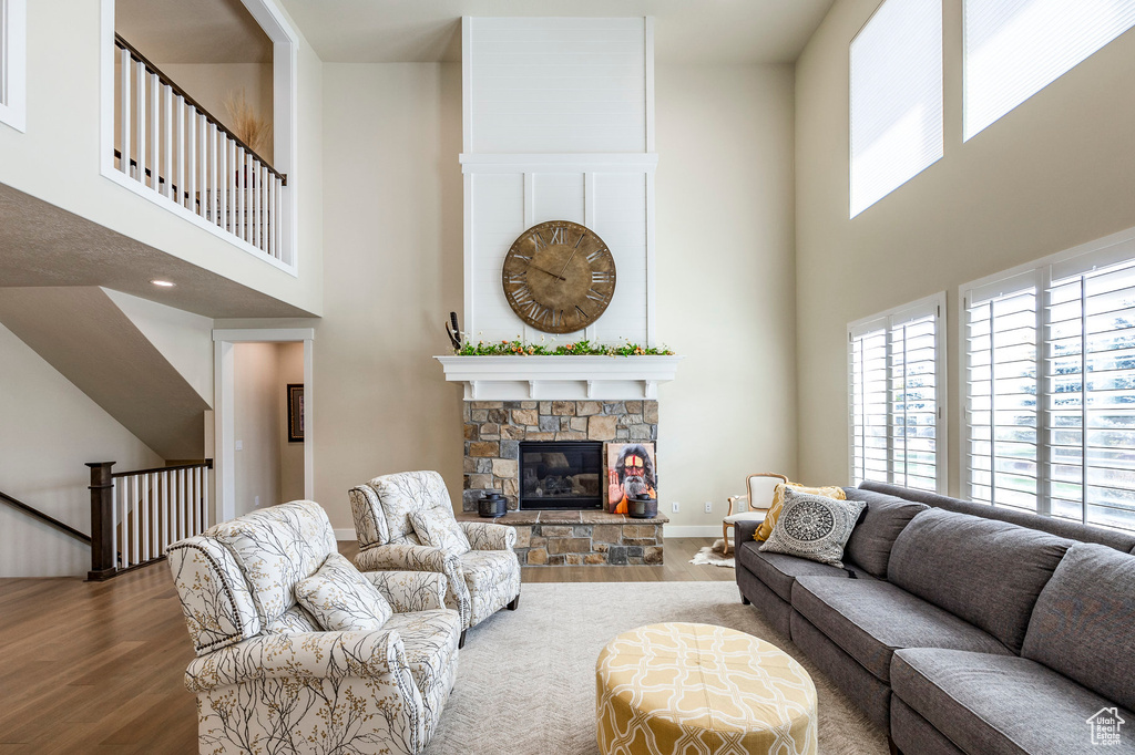 Living room with a high ceiling, a fireplace, and wood-type flooring