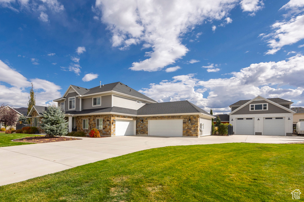 View of front of property featuring a front yard and a garage