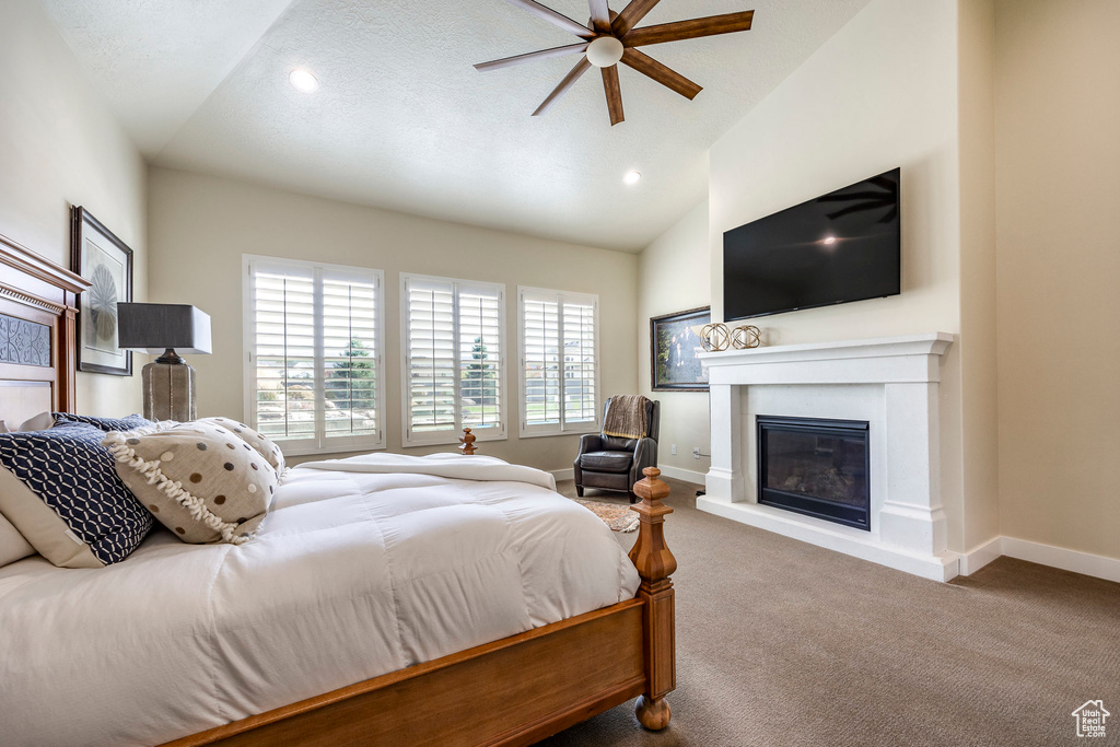 Bedroom with vaulted ceiling, carpet floors, and ceiling fan