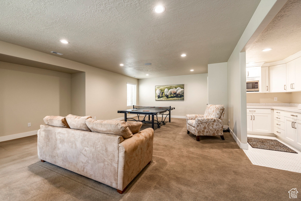 Living room with a textured ceiling and light colored carpet