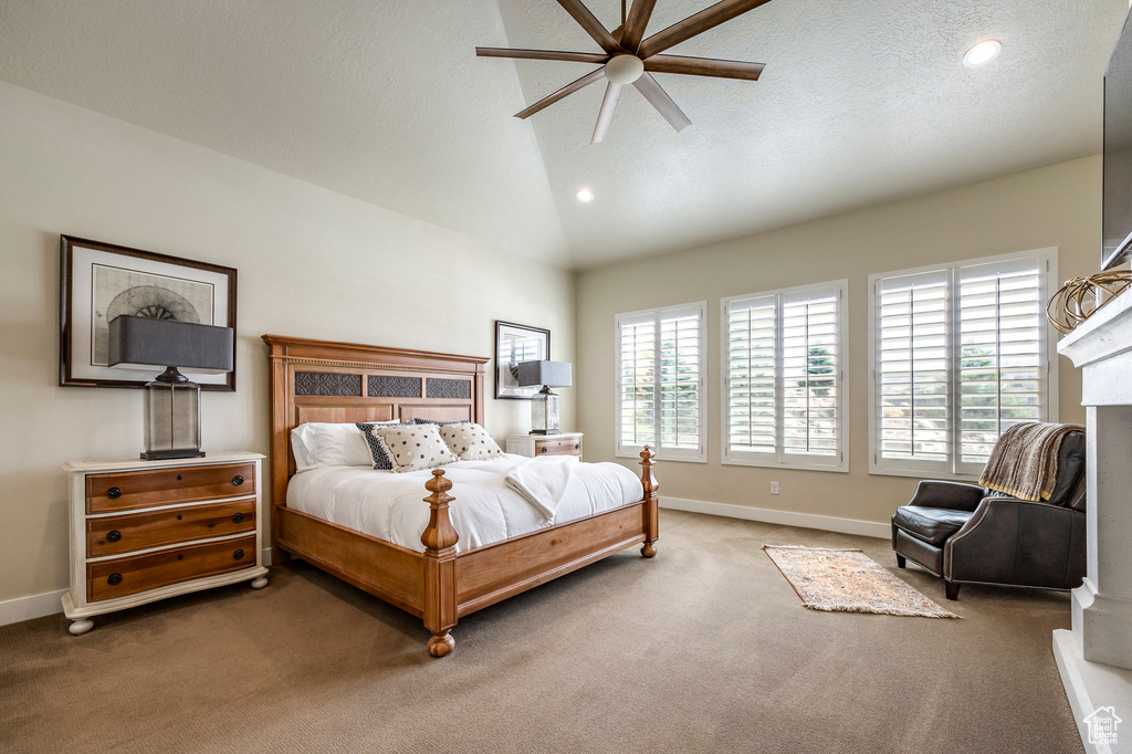 Bedroom featuring multiple windows, dark carpet, vaulted ceiling, and ceiling fan