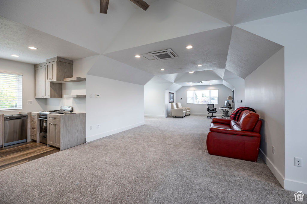 Interior space featuring vaulted ceiling, a textured ceiling, a wealth of natural light, and ceiling fan