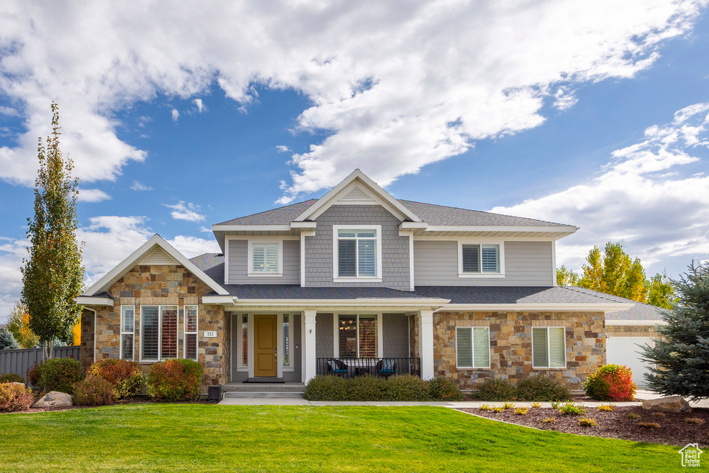 View of front of home featuring covered porch and a front lawn